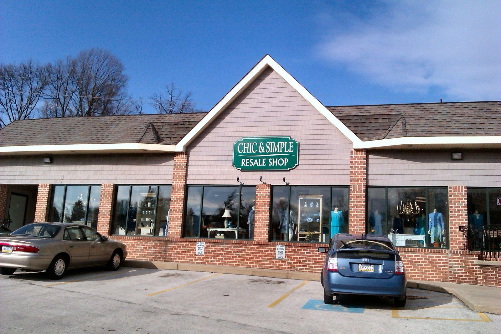 A one-story brick shopping building with a gabled sign on Lancaster Avenue in Berwyn