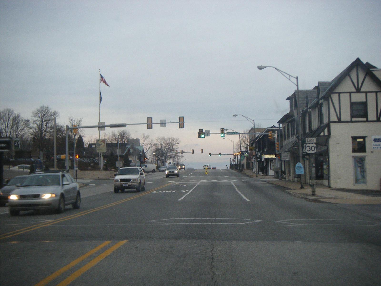 Lancaster Avenue at Valley Road in Paoli, with shops and a Tudor-style building on the corner