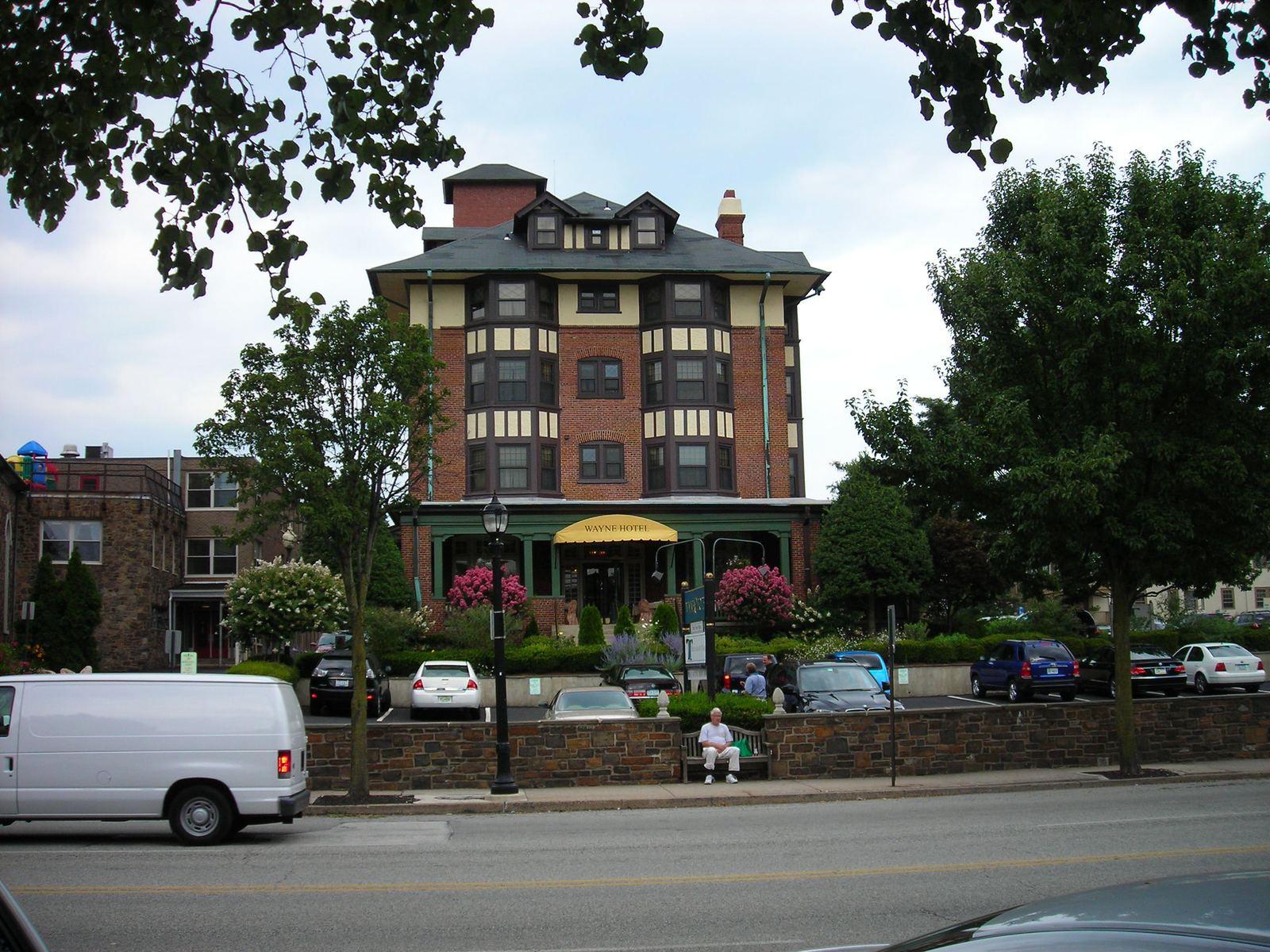 The Wayne Hotel, a brick and stucco building with a corner tower on Lancaster Avenue in Wayne