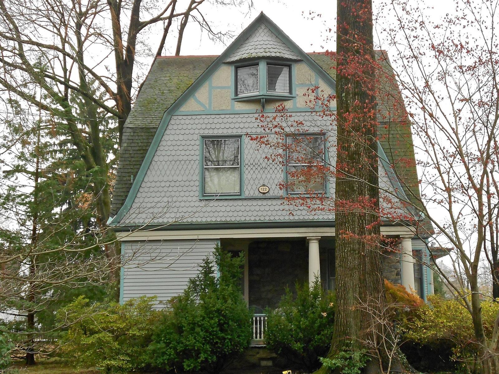 A shingled early-20th-century house with a gambrel roof and porch on Walnut Avenue in the North Wayne Historic District