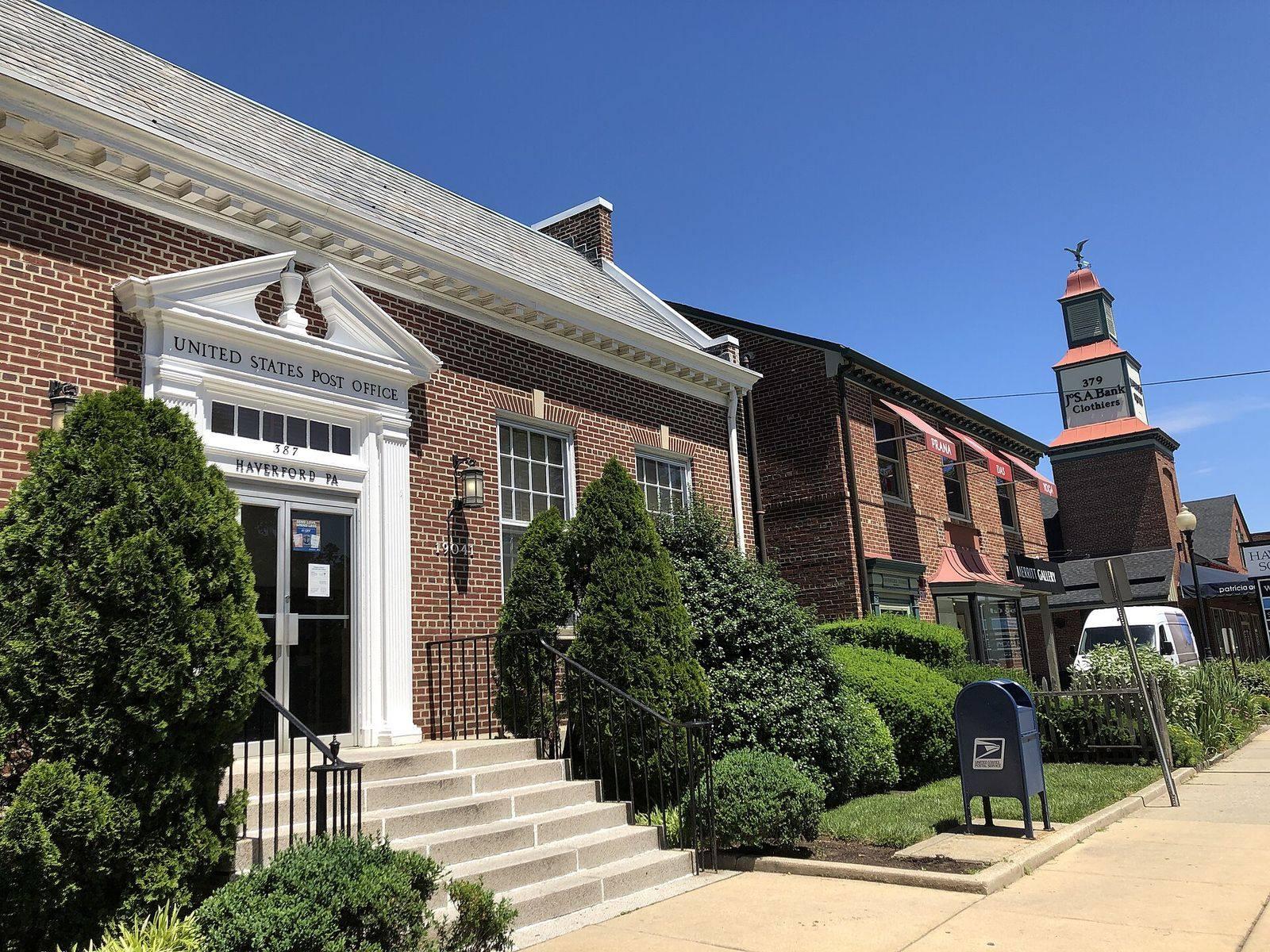 The brick Haverford post office and the clock tower of a neighboring shop on Haverford Road
