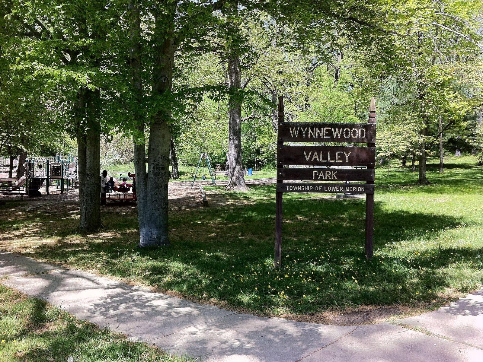 The wooden entrance sign at Wynnewood Valley Park, a Lower Merion Township park, under shade trees
